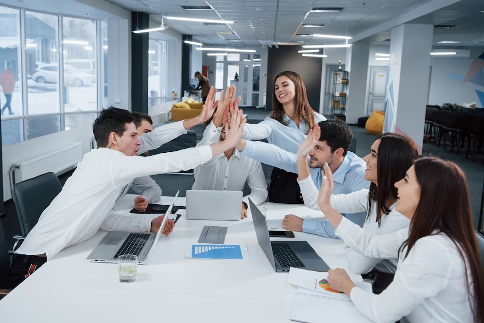 equipo de trabajo celebrando en una junta de negocios
